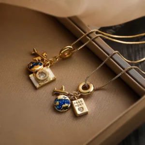 Gold box-chain necklace with epoxy drip plane, camera, and circle pendants, Alkimia Charms jewelry